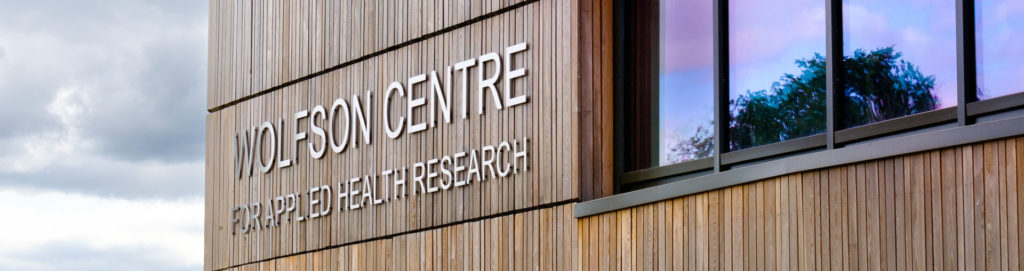 close up of the Wolfson Centre signage against a cloudy sky